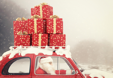 66792349 - santa claus drives a red car full of christmas present