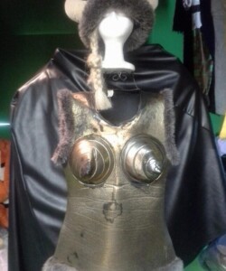 Mannequin wearing a Viking-themed costume with a horned helmet and metallic breastplate, draped in a black cape.